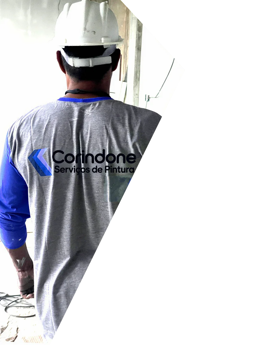 Profissional de capacete e camisa da Corindone, de costas, em uma obra